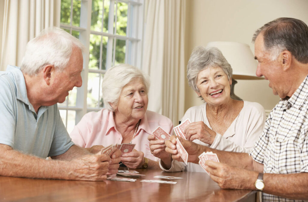 Group of happy elderly people playing cards
