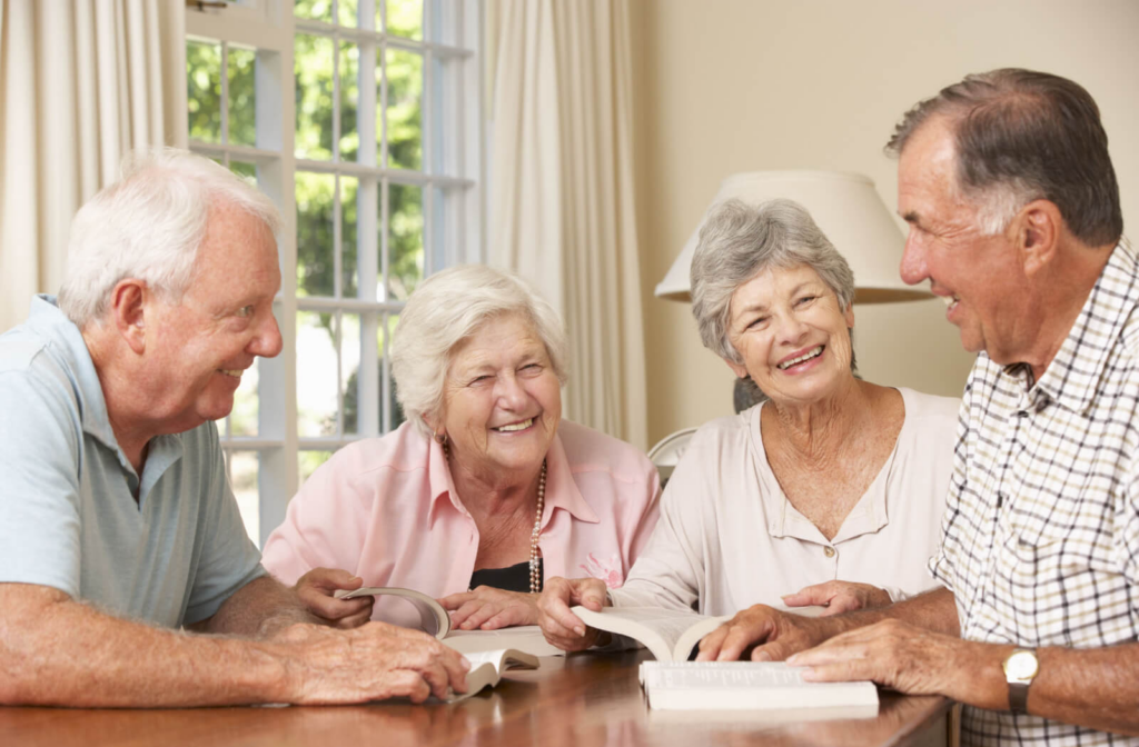 a group of seniors sit around a table in a residential senior living community