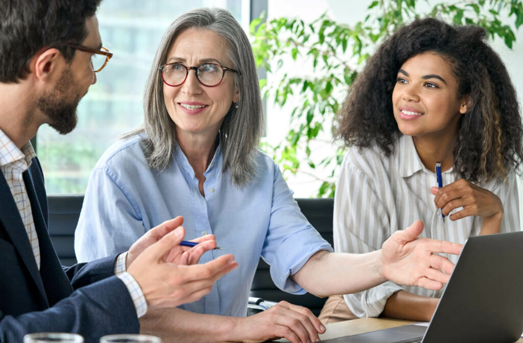 Three professionals discussing the pros and cons of owning an assisted living community.