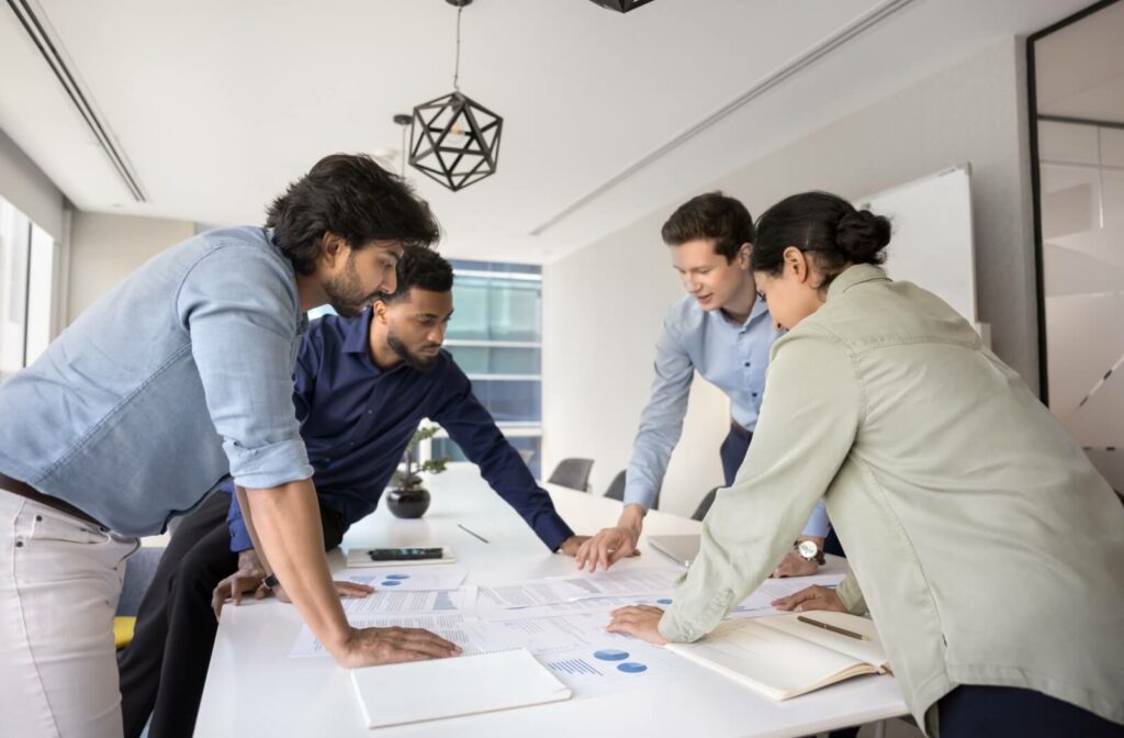 Business team reviewing financial charts and documents together in a modern office during a strategy meeting